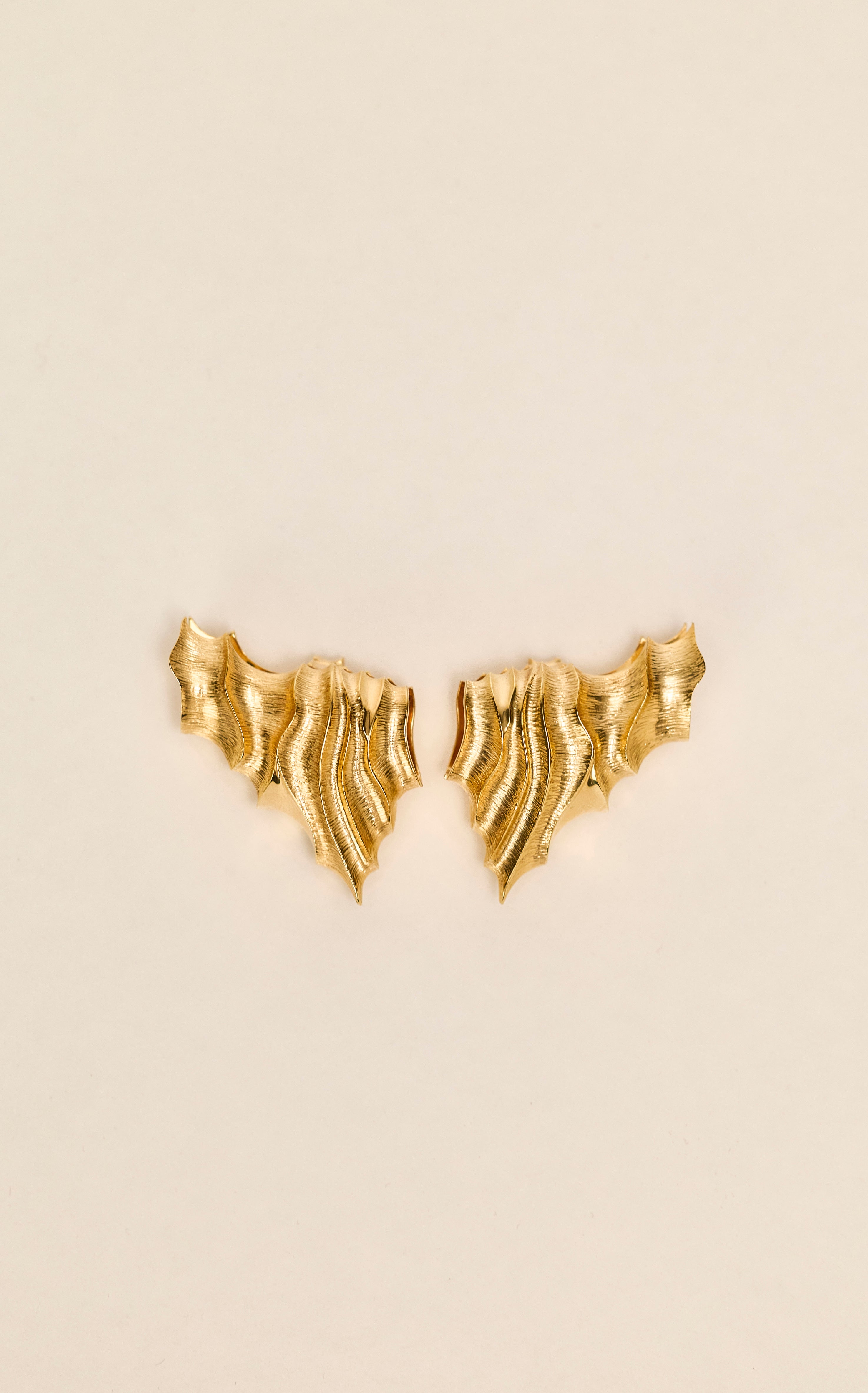 Estuarine Clip earring sculpted in bronze with engraved linear textures, finished in 24k gold plating