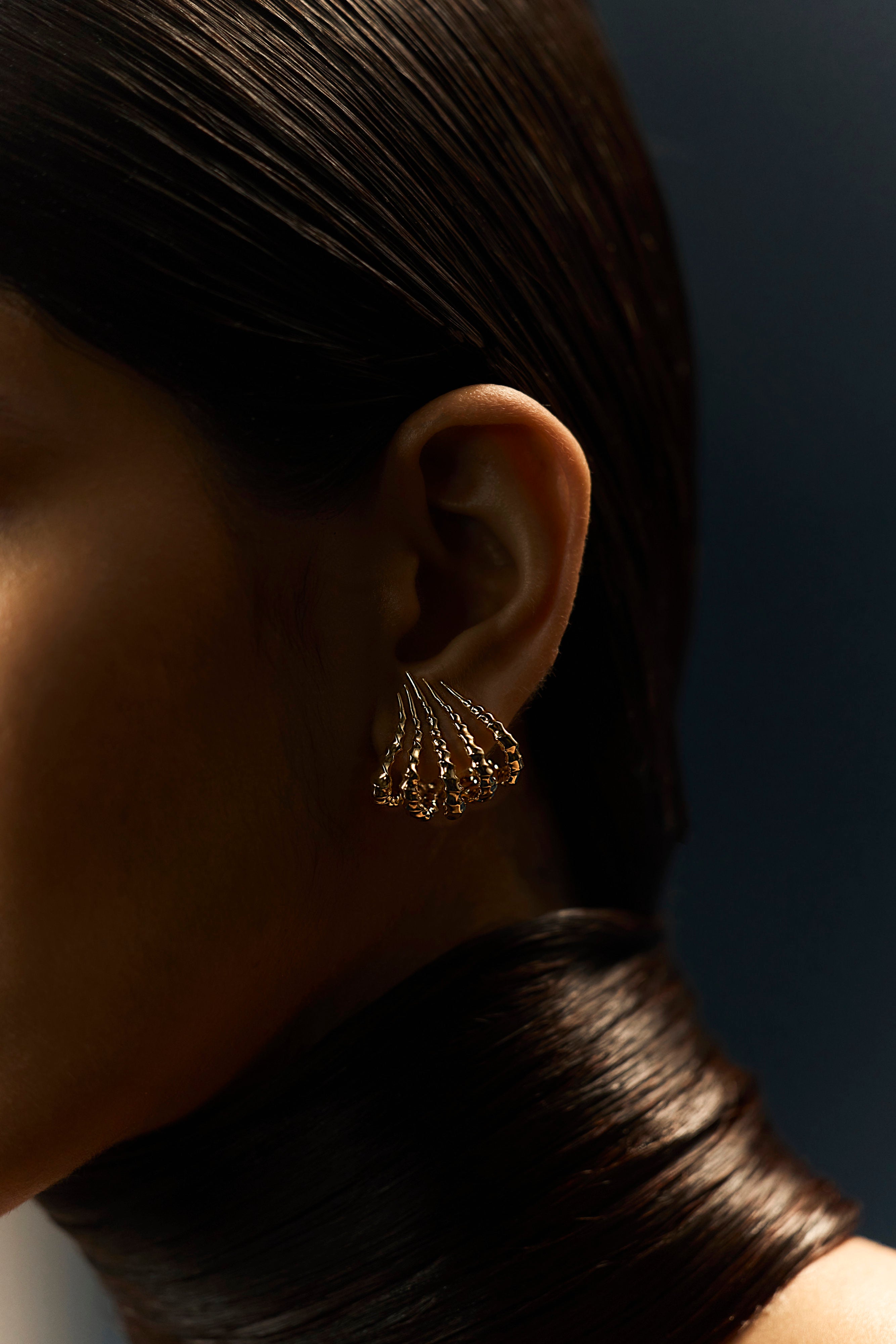 Langmuir Earring sculpted in bronze with rhythmic polished ridges, finished in 24k gold plating