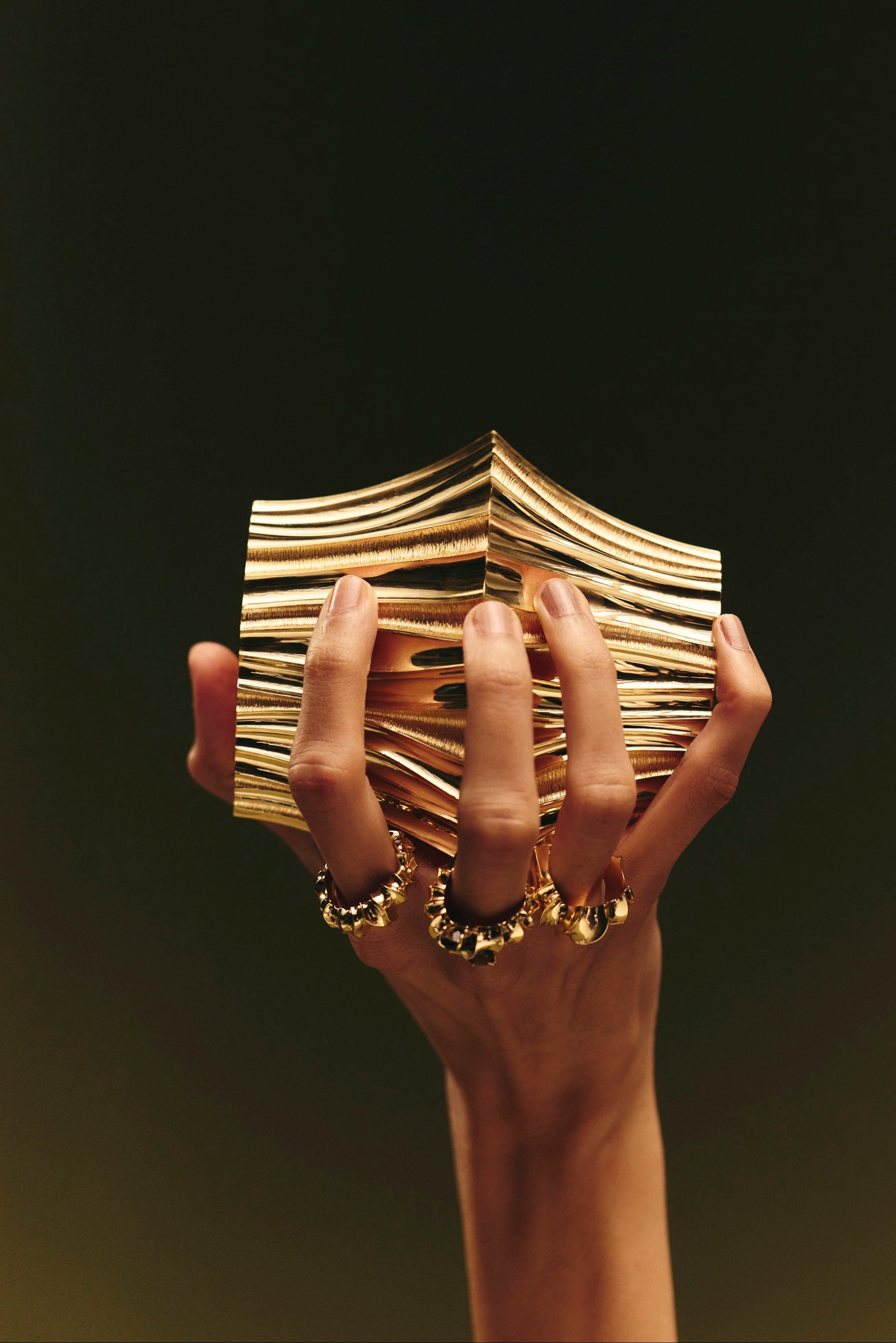 Coriolis Bangle sculpted in bronze with continuous circular textured form, finished in 24k gold plating