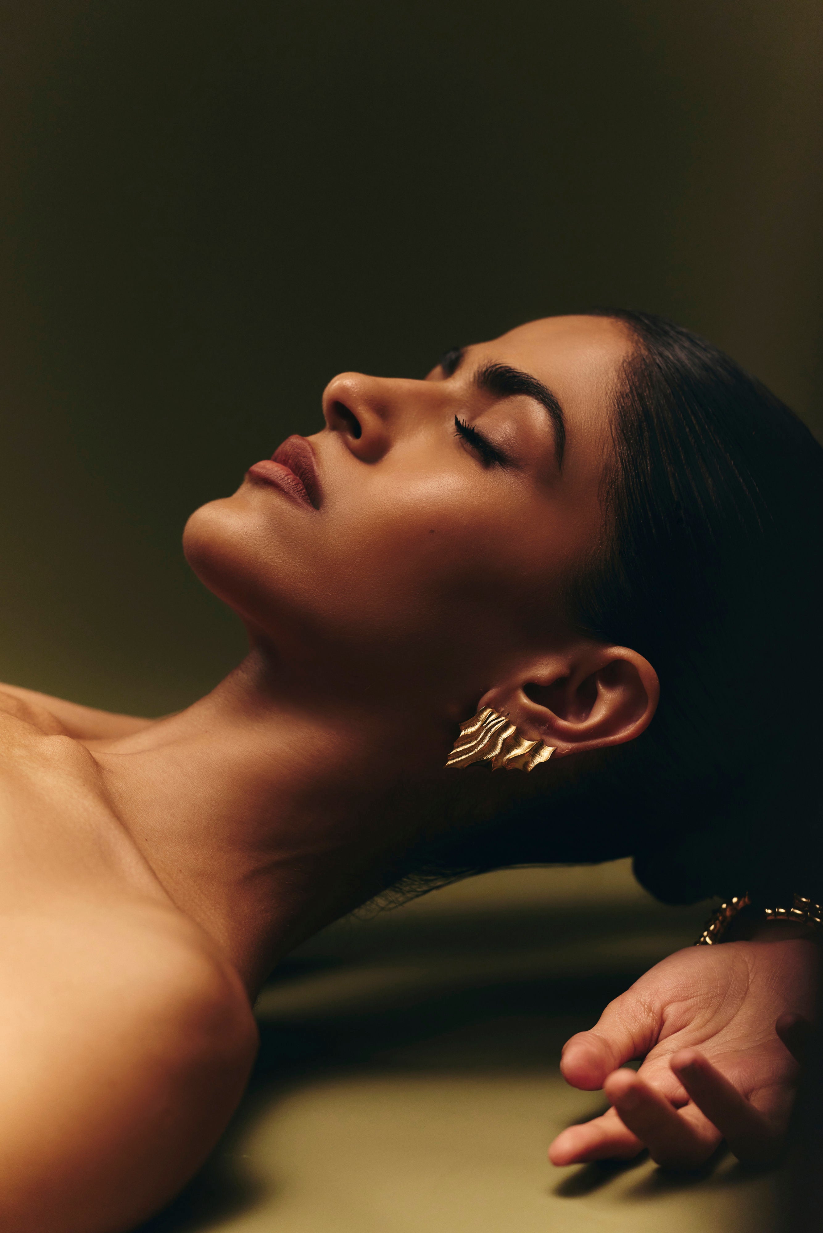 Estuarine Clip earring sculpted in bronze with engraved linear textures, finished in 24k gold plating